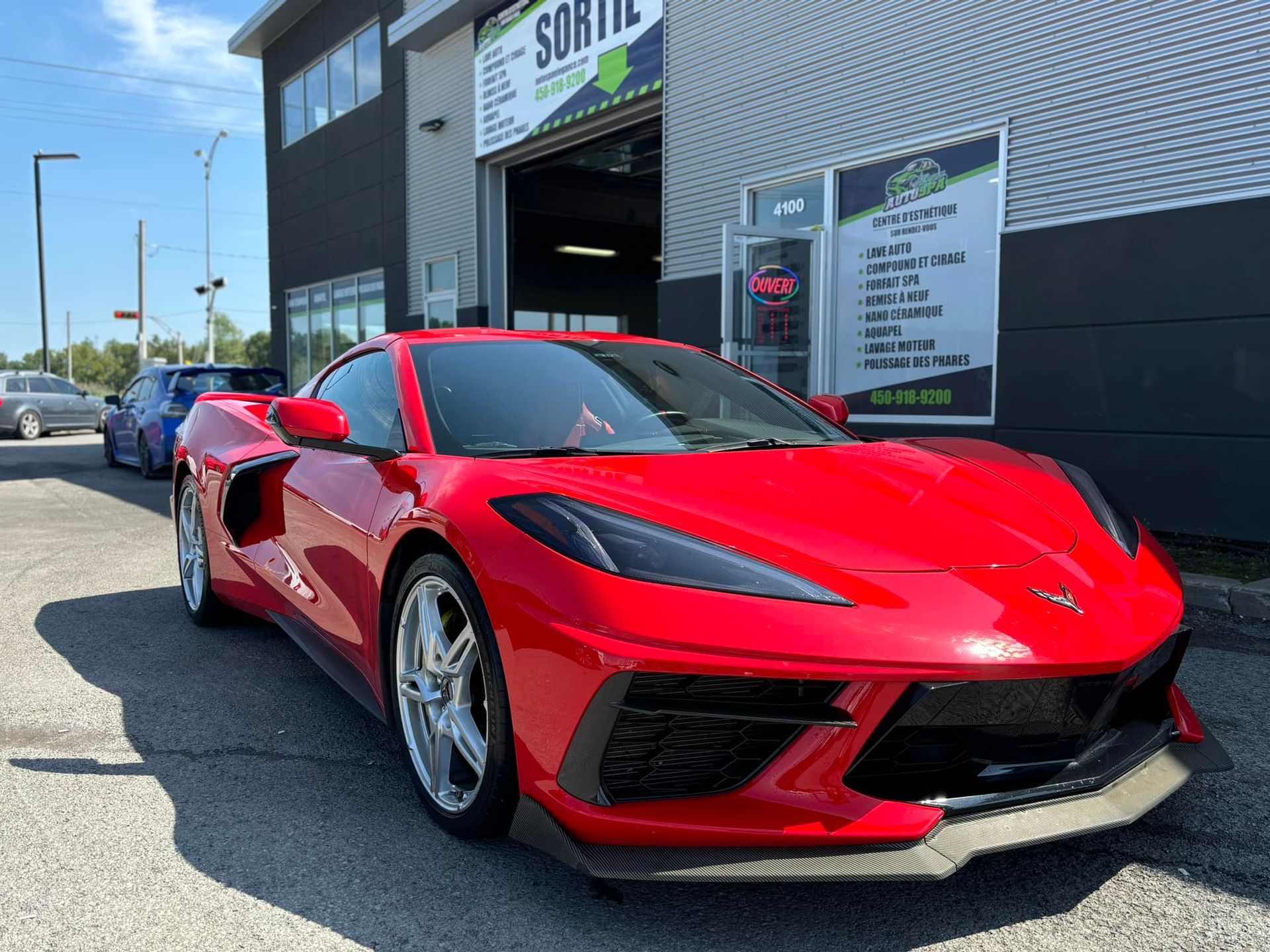 A red sports car is parked in front of a building.