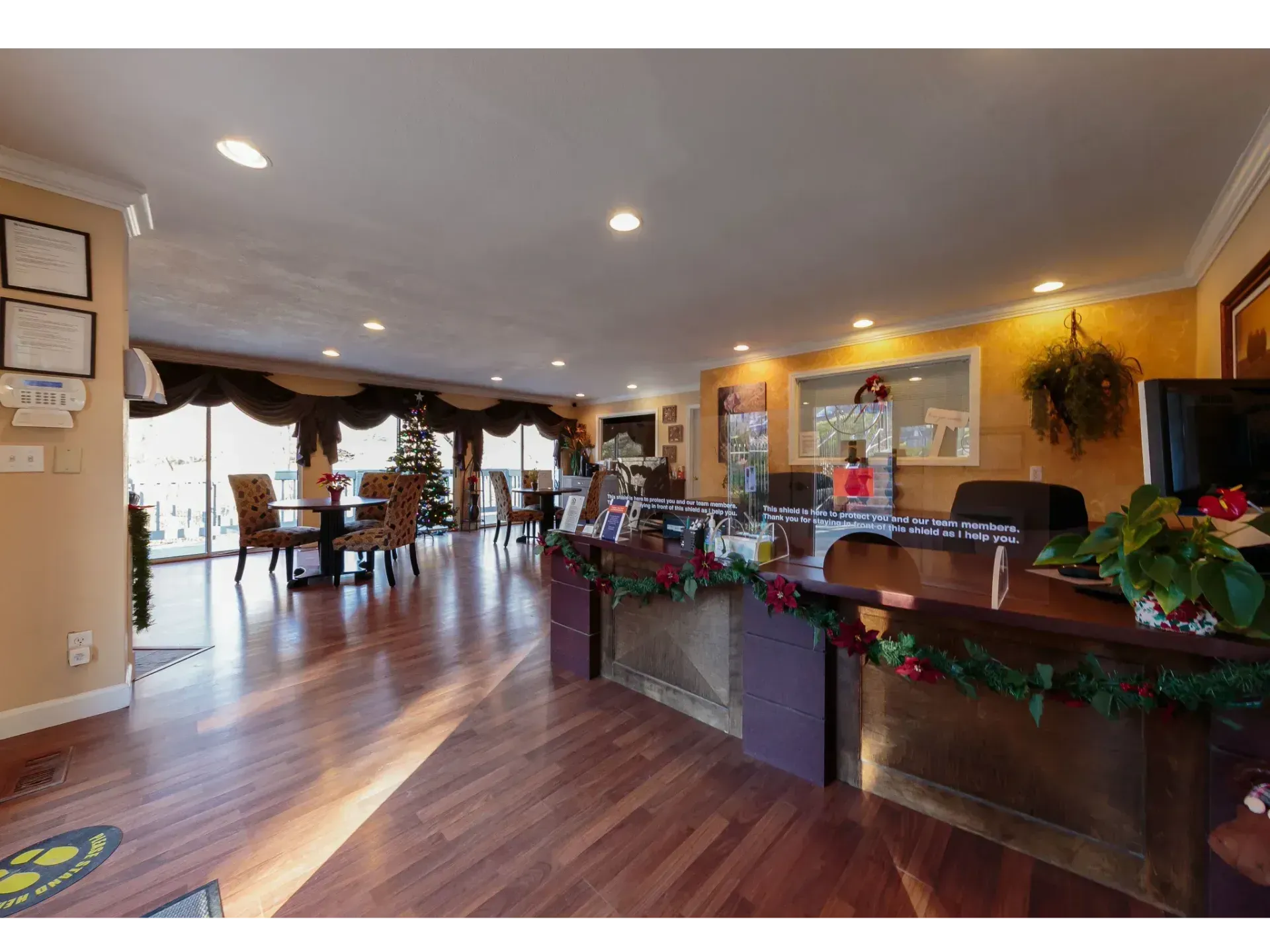 Lobby with wood floors, warm lighting, and a decorated front desk at a hotel or office reception area