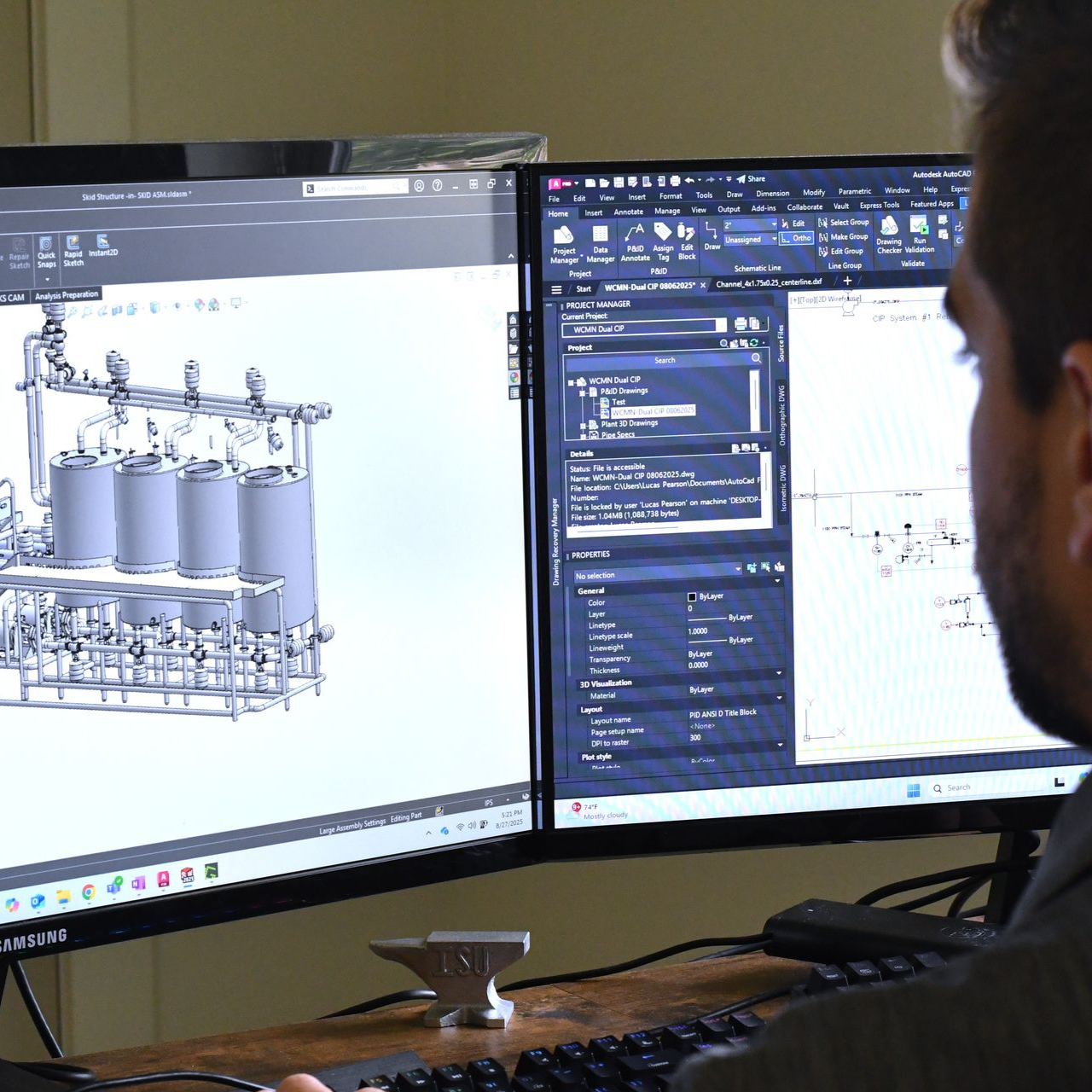 Man working on a computer, viewing a 3D model of industrial equipment.