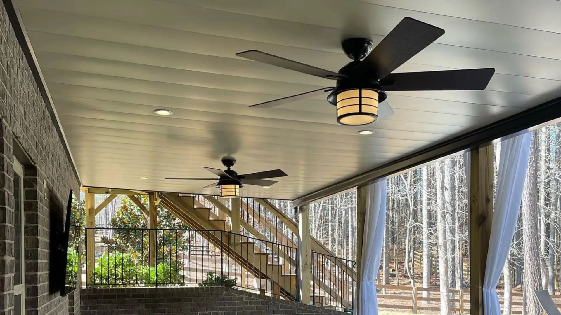 Aluminum under the deck ceiling that includes two ceiling fans, outdoor lighting, and drainage.