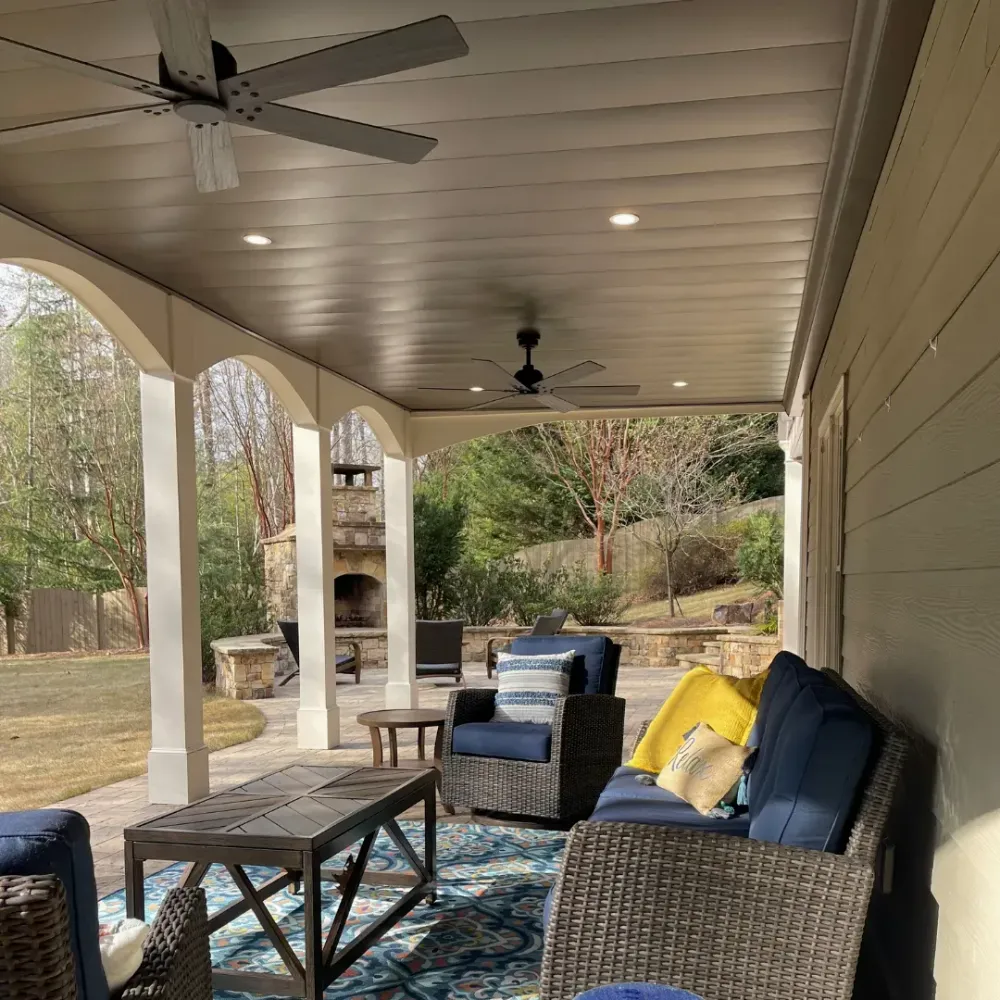 Under deck patio design with added features such as ceiling fans and LED lighting.