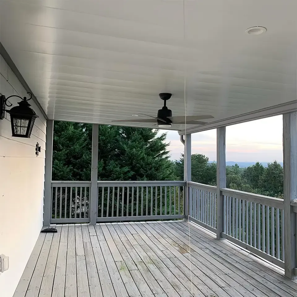 White aluminum under-deck system that includes a hardscaping design, one ceiling fan, and outdoor lighting.