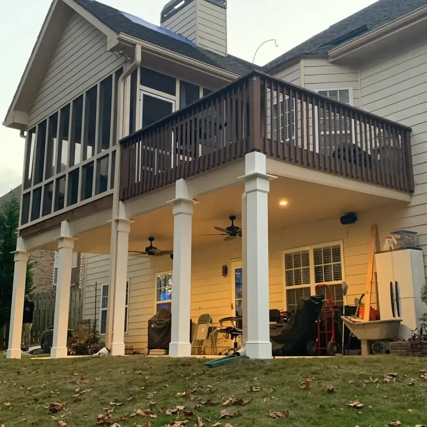 Aluminum under-deck system that includes a hardscaping design, two ceiling fans, outdoor lighting, and Bluetooth speakers.