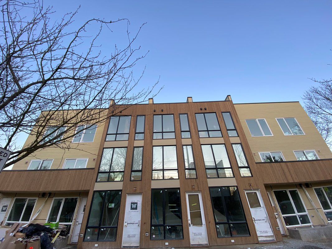 A large building with a lot of windows and doors is under construction.