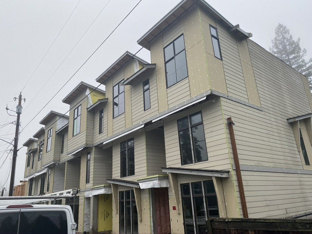 A row of houses with a van parked in front of them.