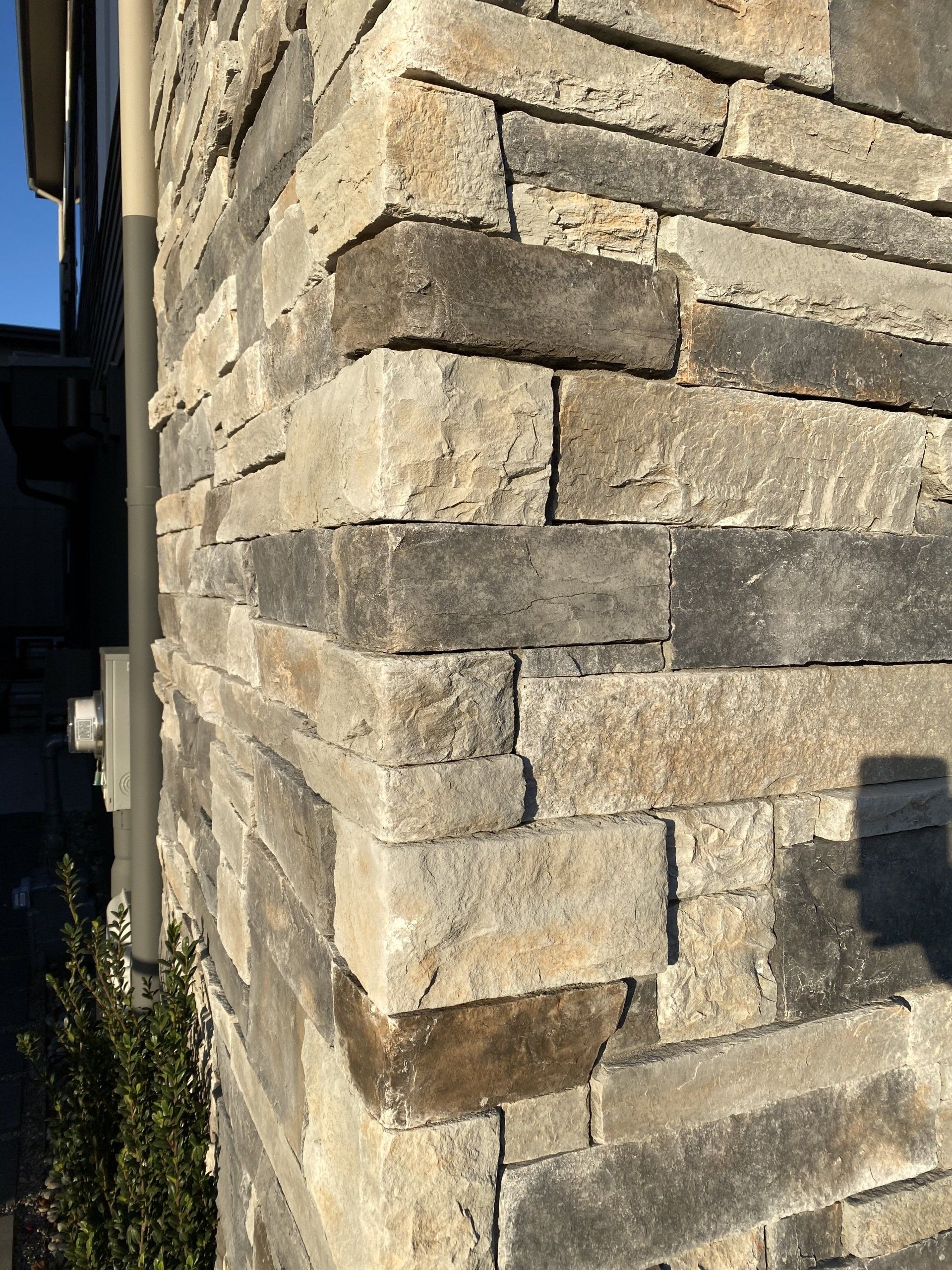 A close up of a stone wall on the side of a house.