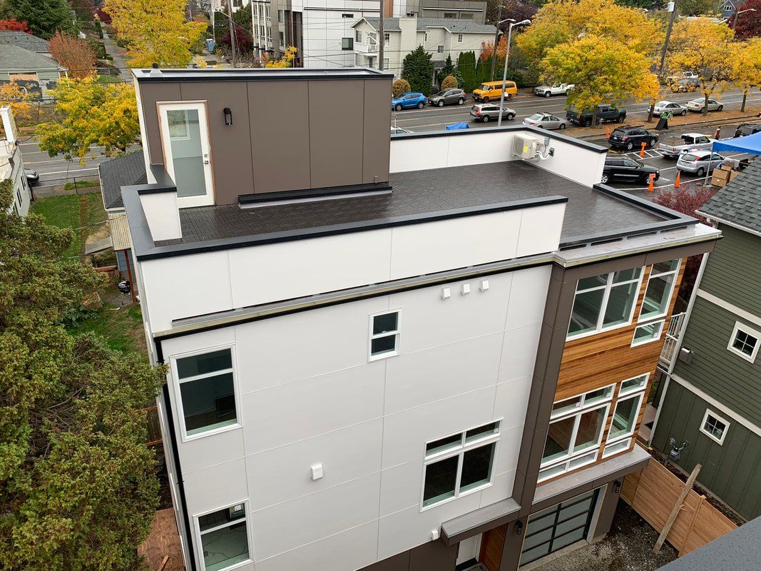 An aerial view of a building with a flat roof and a lot of windows.