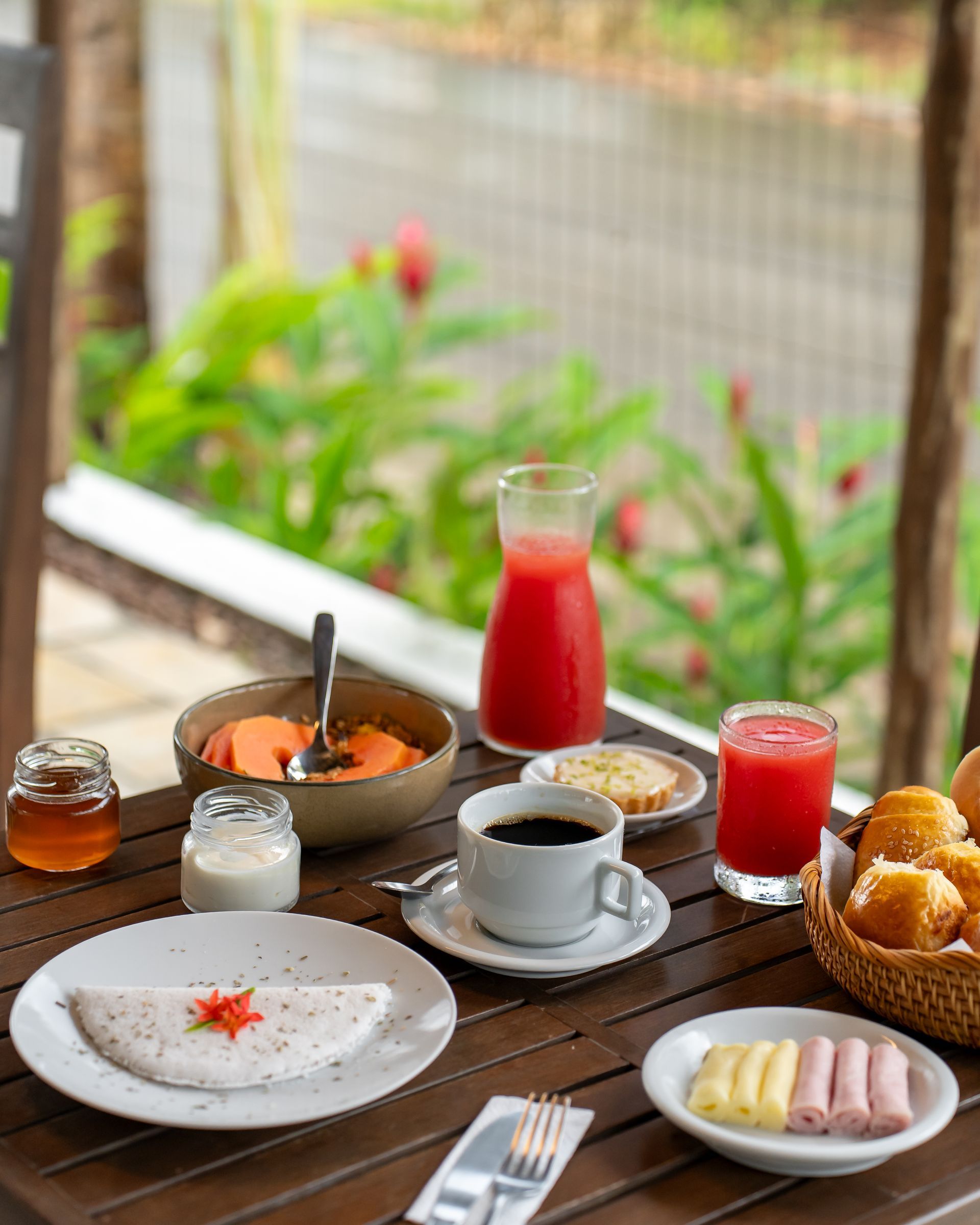 Uma mesa de madeira coberta com pratos de comida e bebidas.