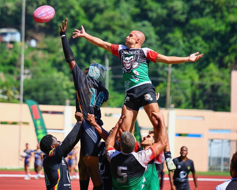 Rugby players leap for a high ball during a lineout on a field