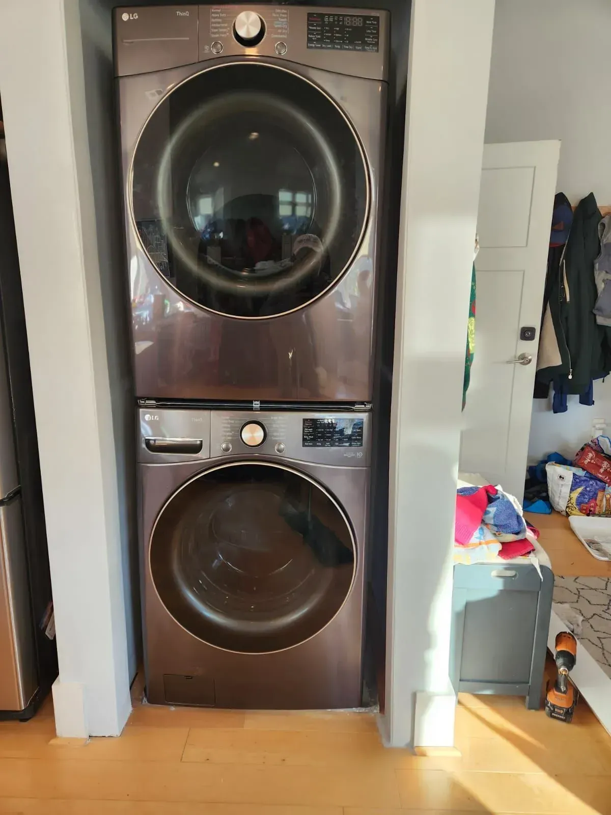 Stacked black washer and dryer with round glass doors in a laundry closet.