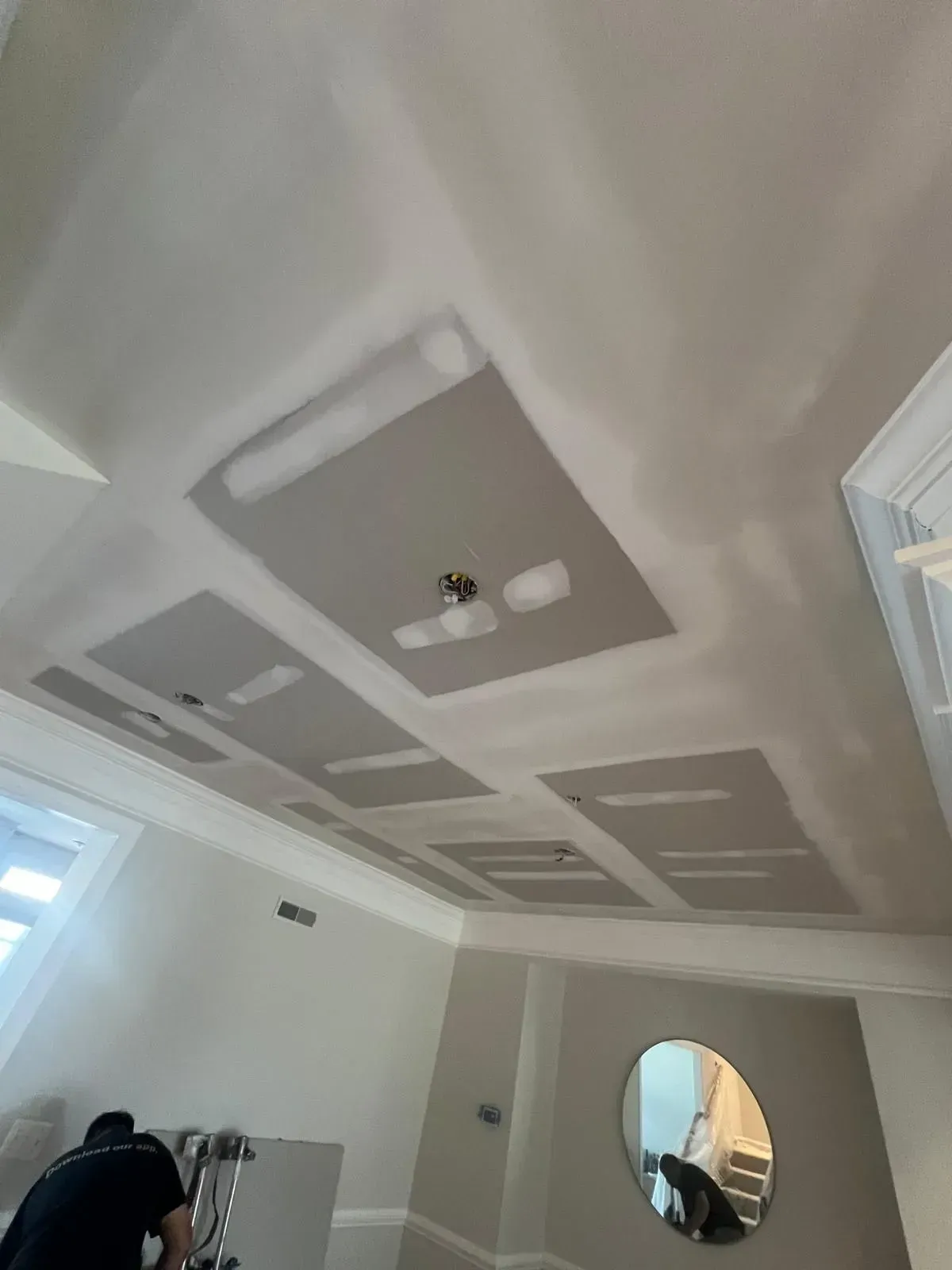 White room ceiling with gray recessed panels and lights, seen from below