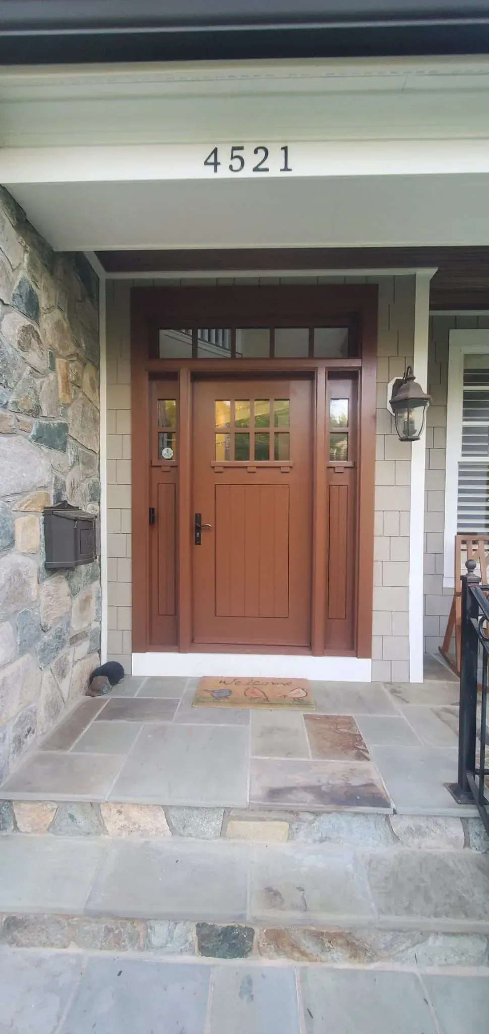 Front entrance with wooden double doors, stone steps, and house number 4321 above the porch.