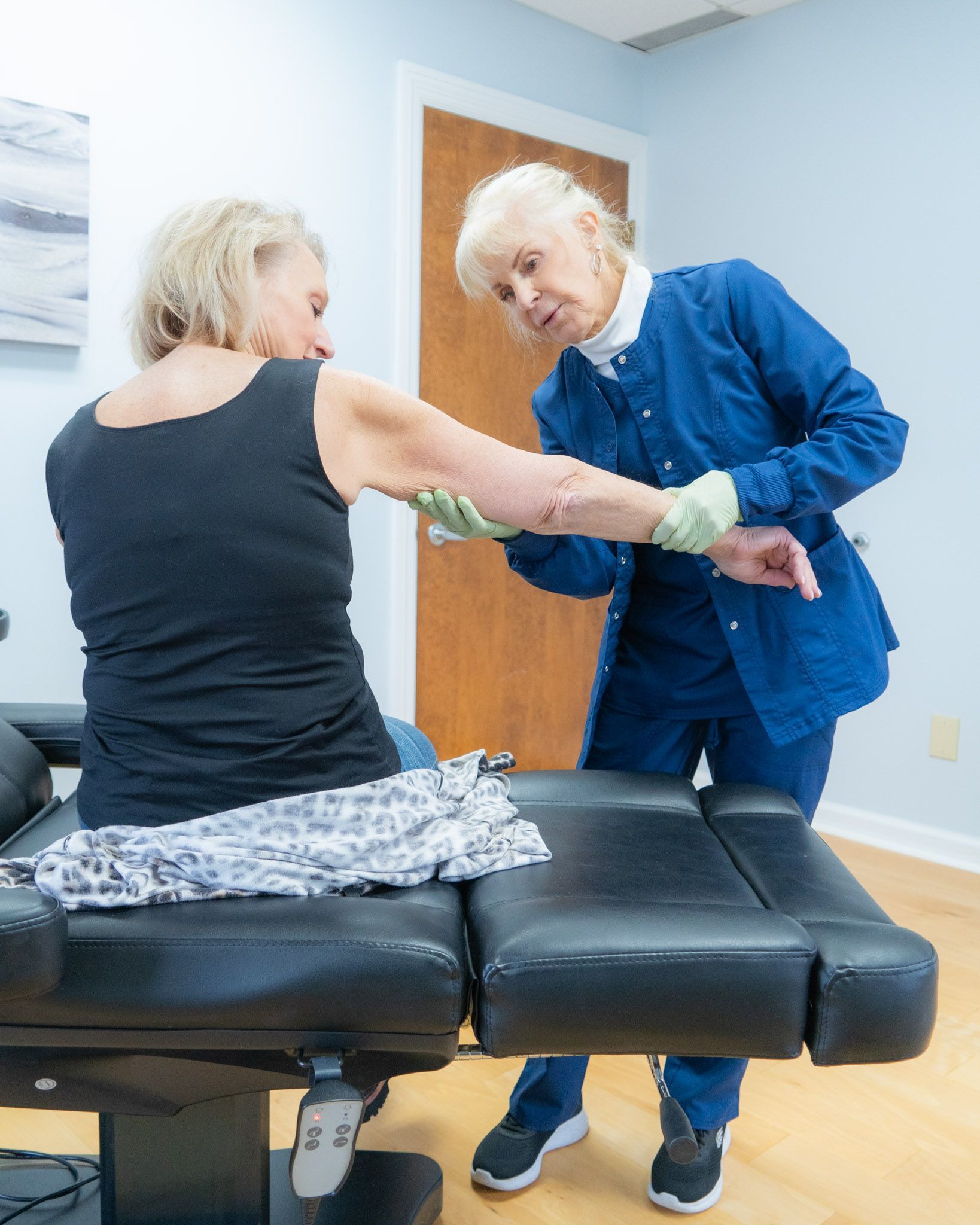 Woman receiving medical care on her arm from a doctor in a clinic setting.