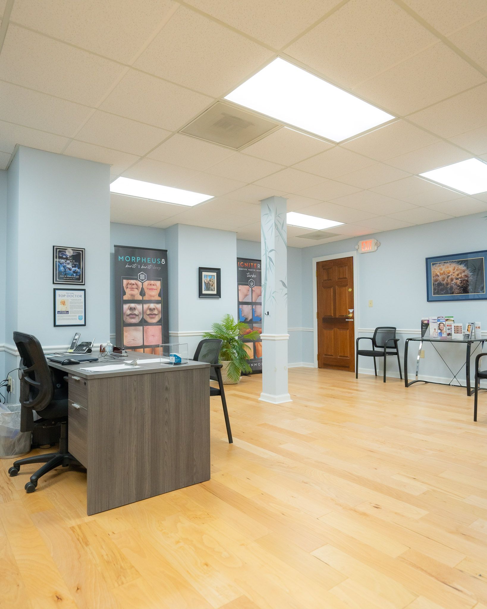 Reception area with light wood floors, blue walls, and a desk.