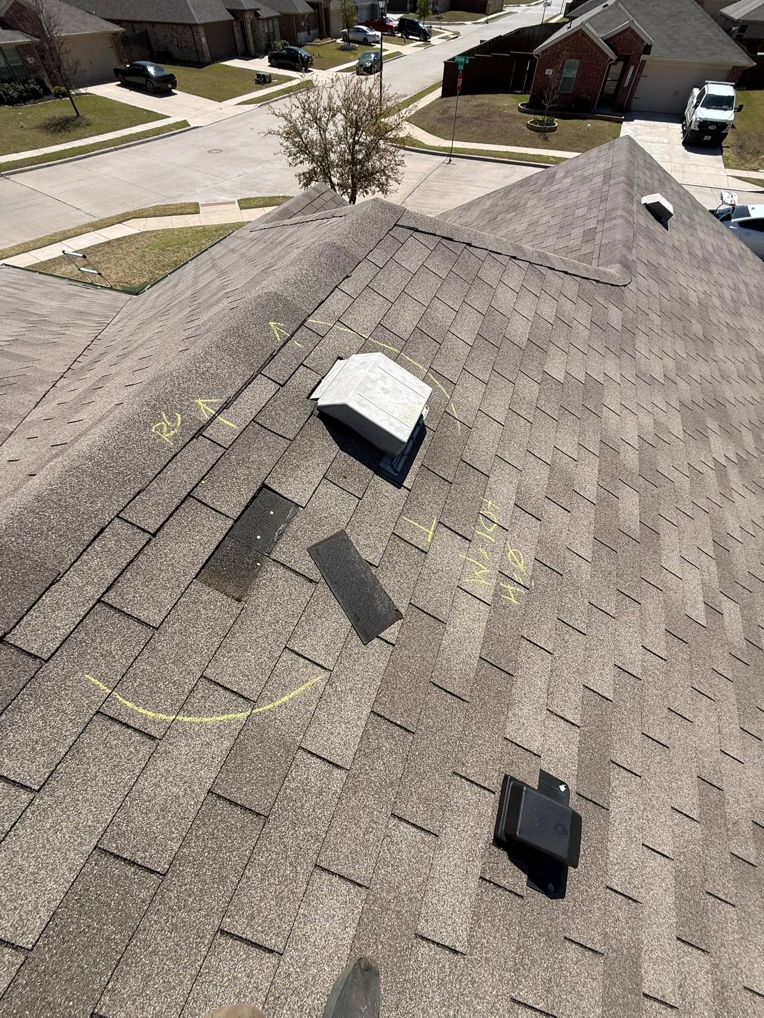 Rooftop with two vents/shingles, overlooking a suburban street and houses