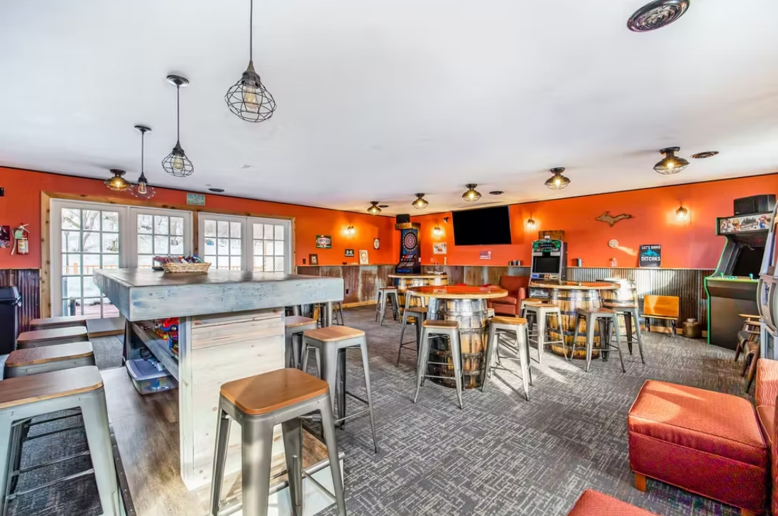 Bright orange café interior with stools, tables, and large windows in a spacious seating area