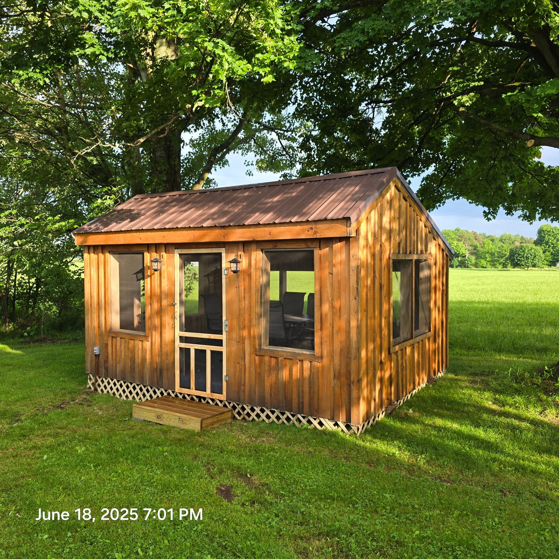 White tiny house with black trim, door, and roof, on a grassy lawn with a winding sidewalk.