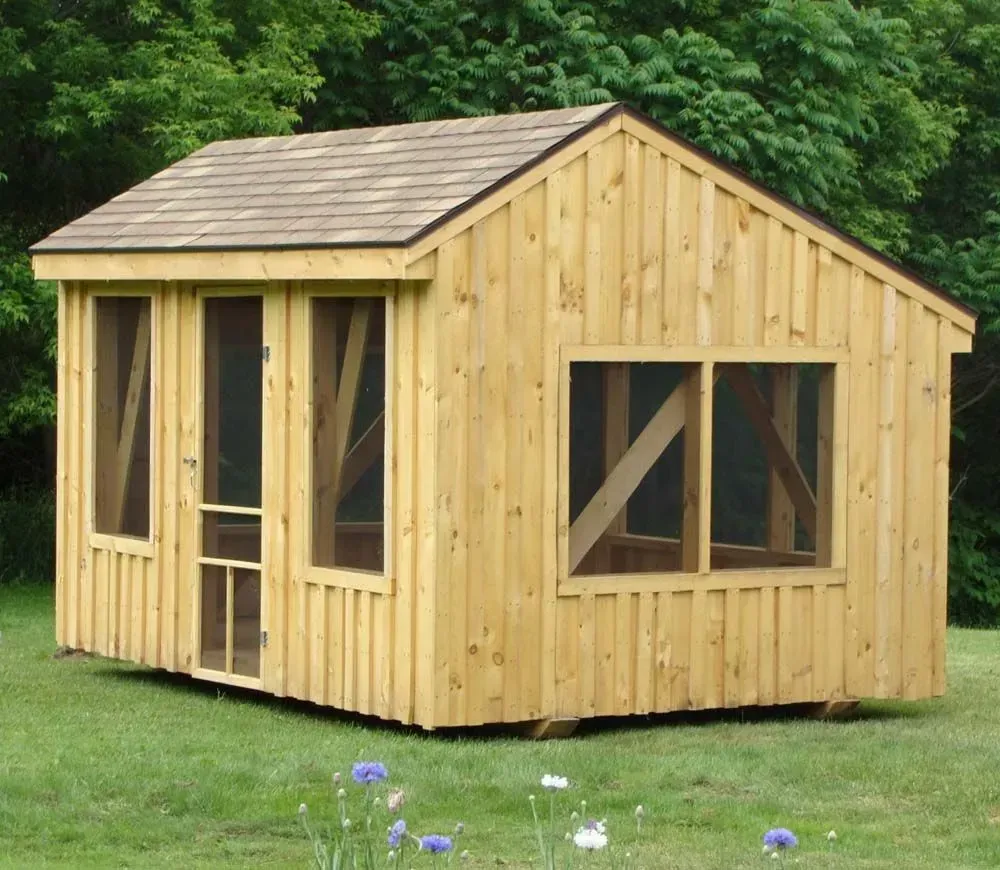 Wooden shed with screens, brown roof, set in a grassy yard.