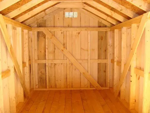 Interior of a wooden shed with wood walls and floor, empty, natural wood color.