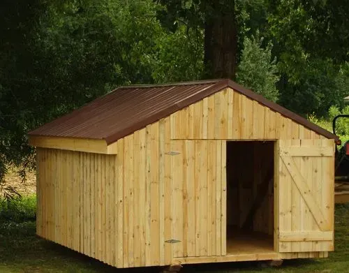 Wooden shed with a brown metal roof and open door in a grassy area.