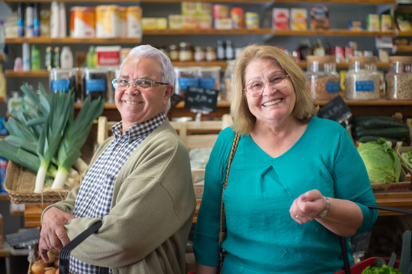 A man and a woman are standing next to each other in a grocery store.