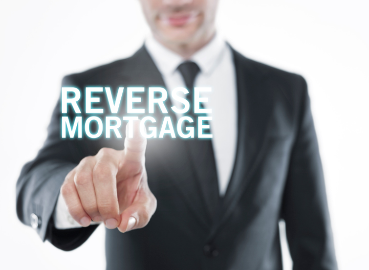 A man in a suit is pointing at the word reverse mortgage
