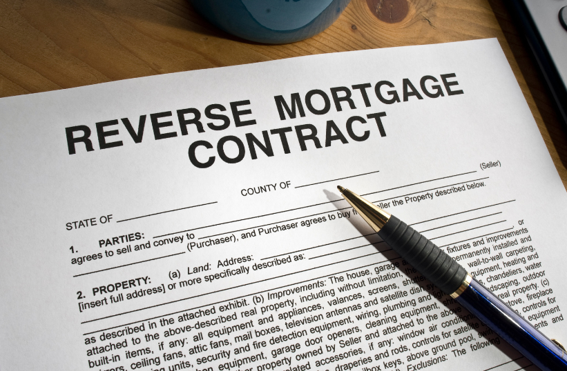 A pen rests on top of a reverse mortgage contract