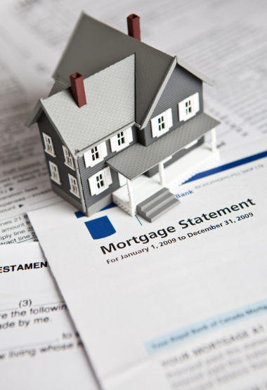 A model house sits on top of a mortgage statement