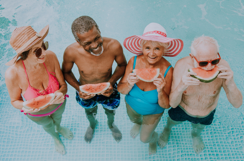 A group of people are eating watermelon in a swimming pool.
