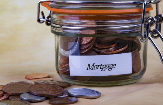 A jar filled with coins and a label that says `` mortgage ''.