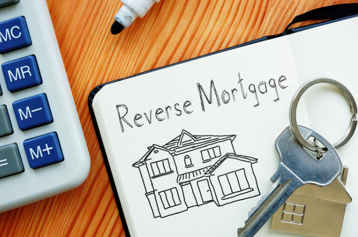 A notebook with a drawing of a house and the words reverse mortgage written on it