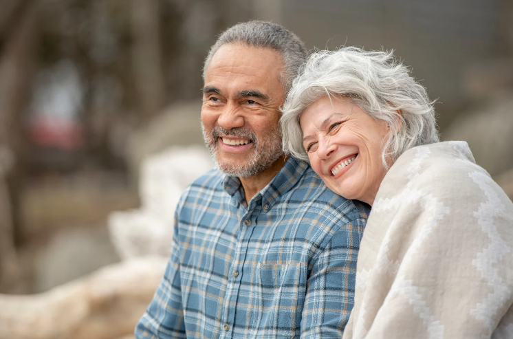 A man and a woman are sitting next to each other and smiling.