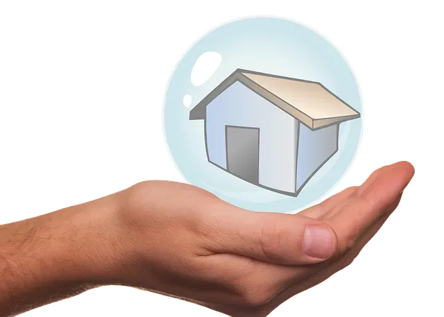 A hand is holding a bubble with a house inside of it