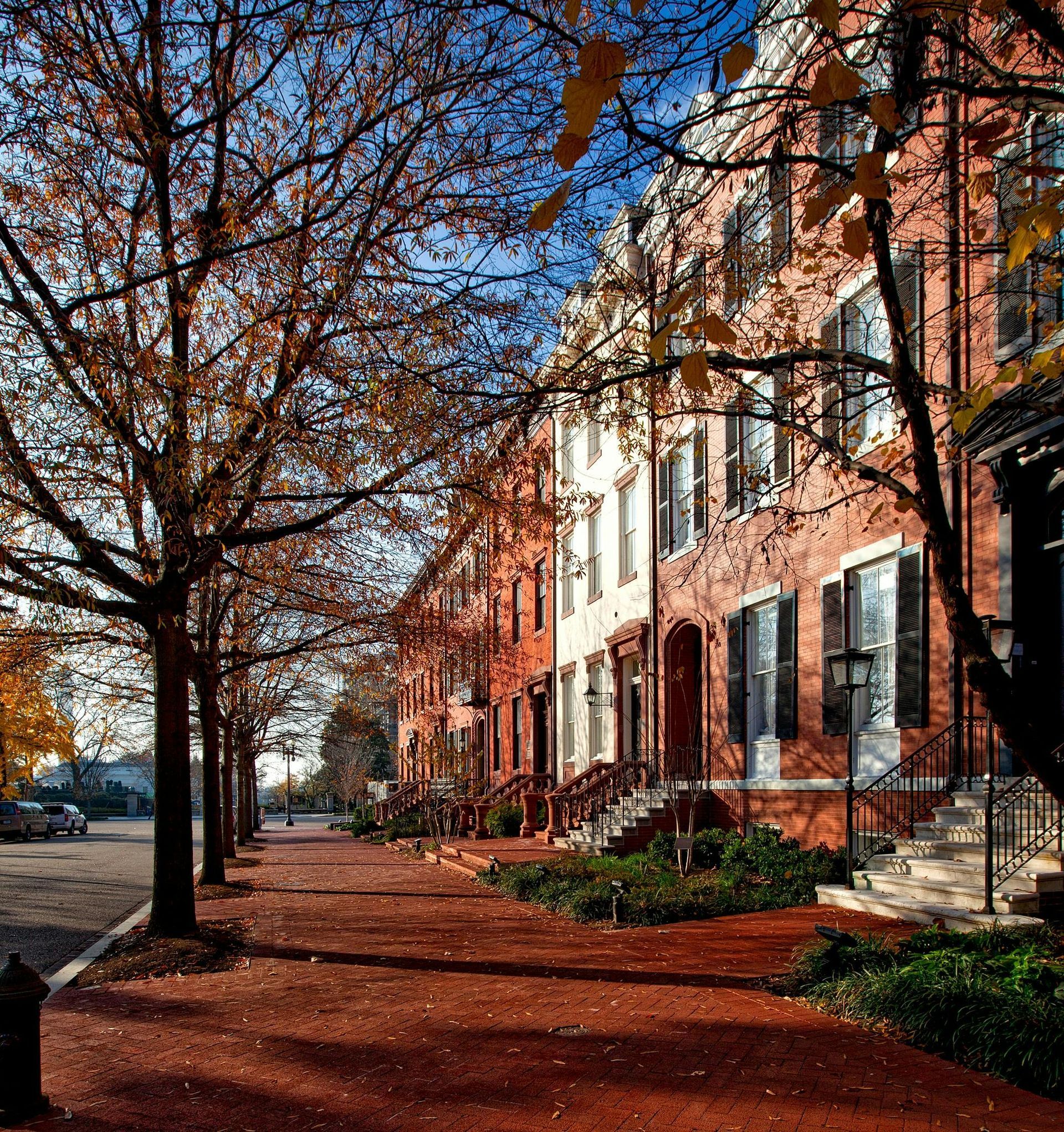 A row of brick buildings with trees in front of them