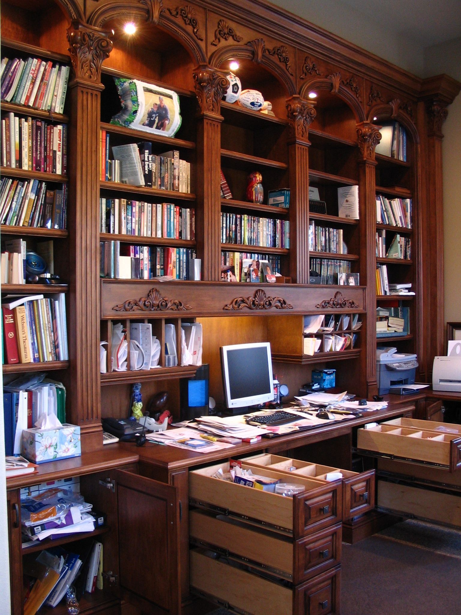 Dark wood home office with built-in bookshelves, desk, and computer.