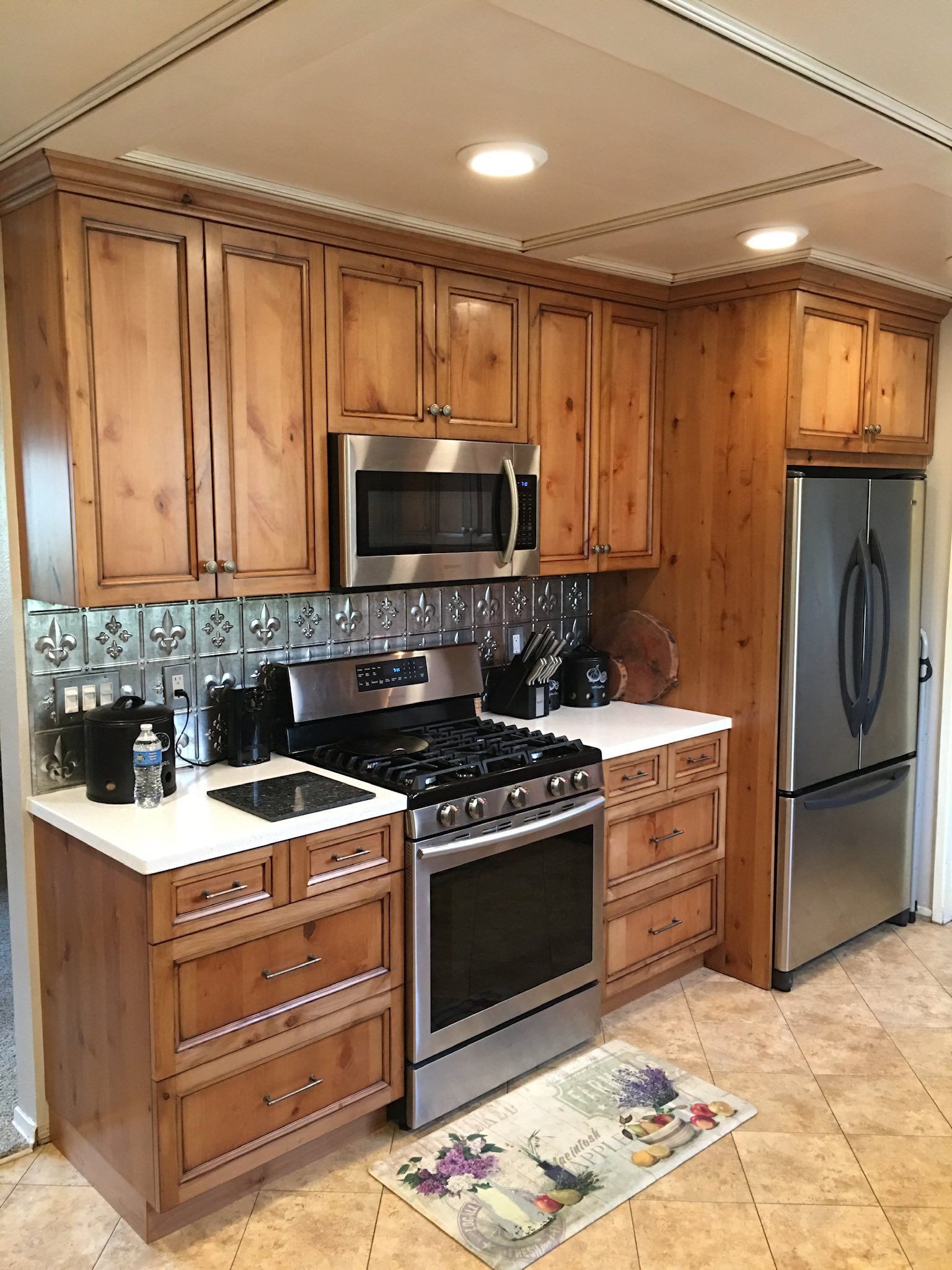 Kitchen with light wood cabinets, stainless steel appliances, and tile backsplash.