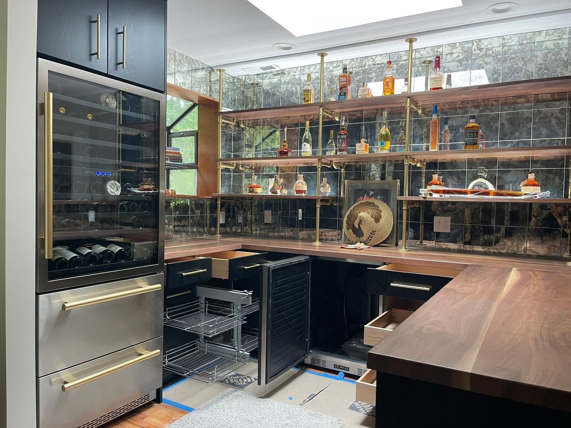 Home bar with a wine fridge, shelves of liquor, and a dark wood countertop.