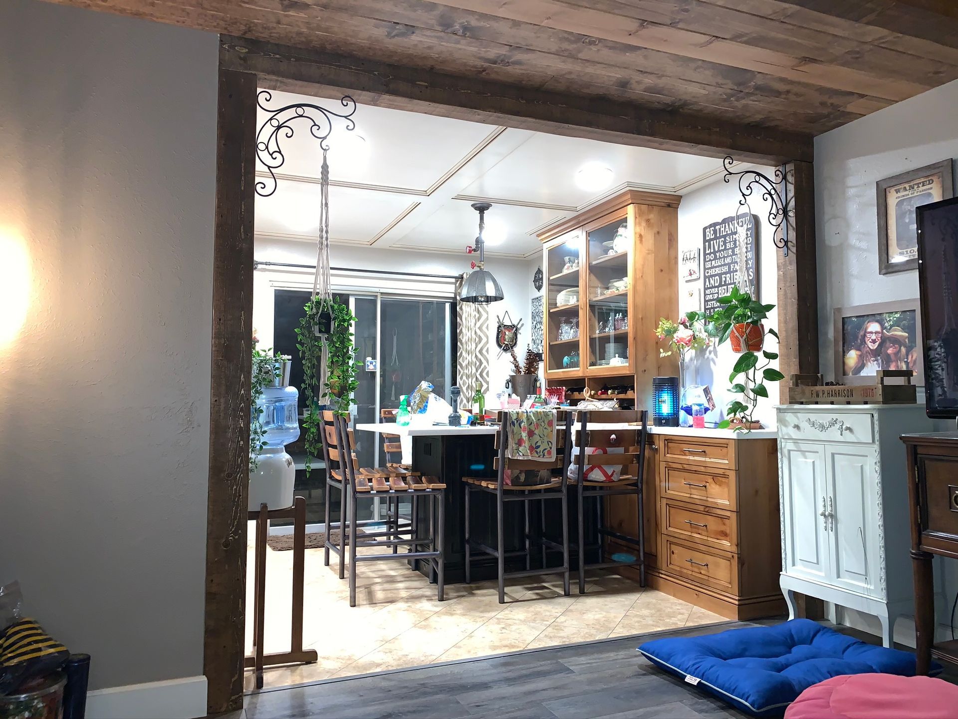 An open doorway frames a kitchen with a bar, cabinets, and a water cooler.