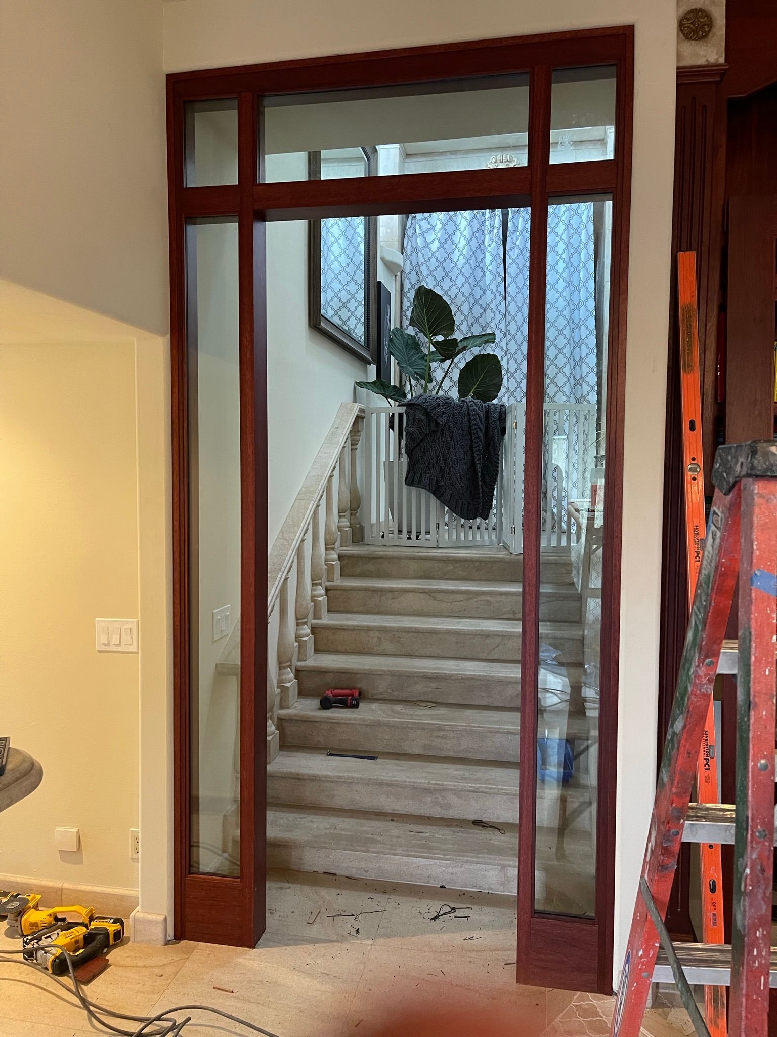Wooden framed doorway with glass panels, leading to staircase. Red frame, light walls.
