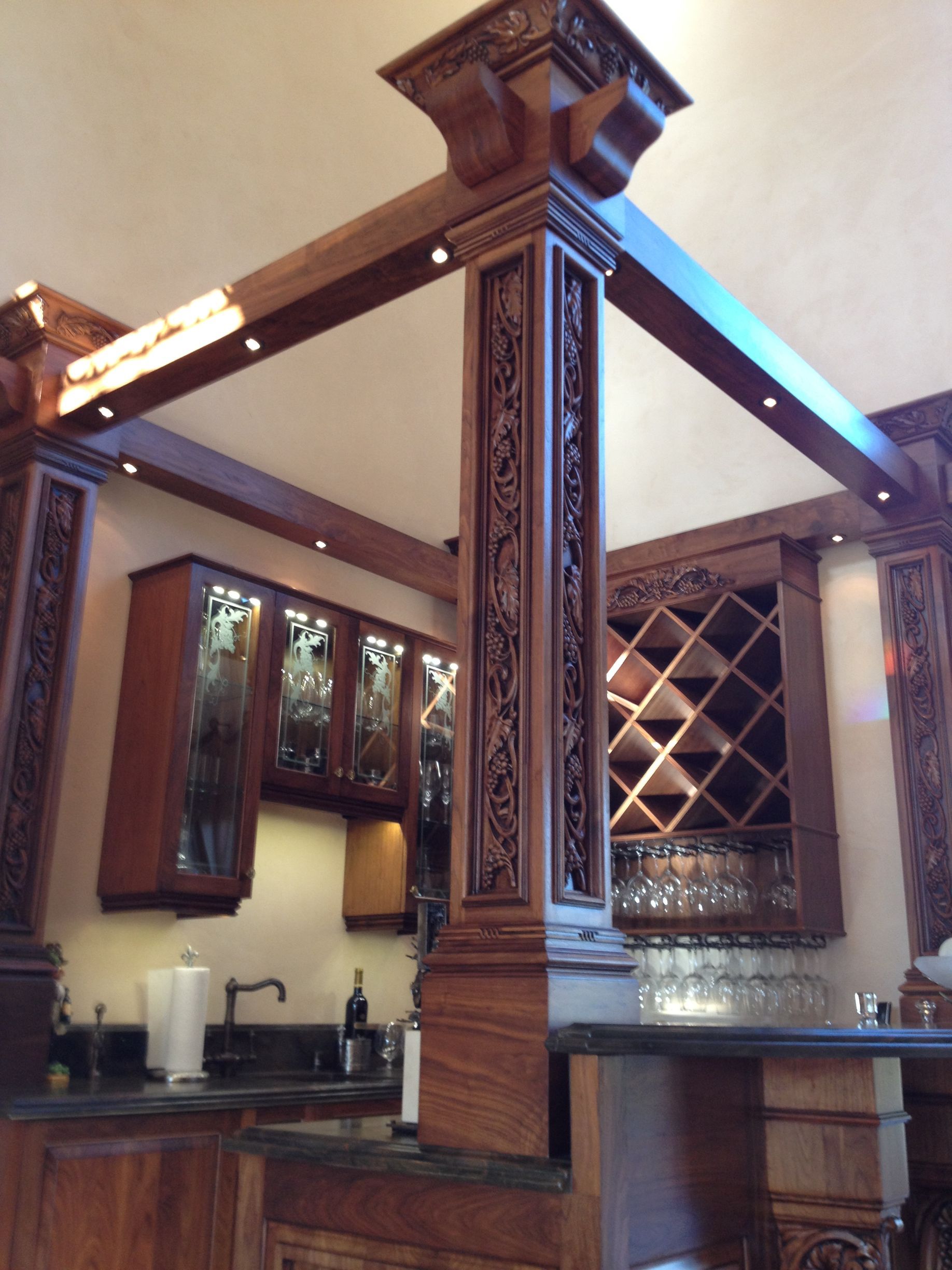 Ornate wooden bar area with carved details, built-in cabinetry, and a wine rack.