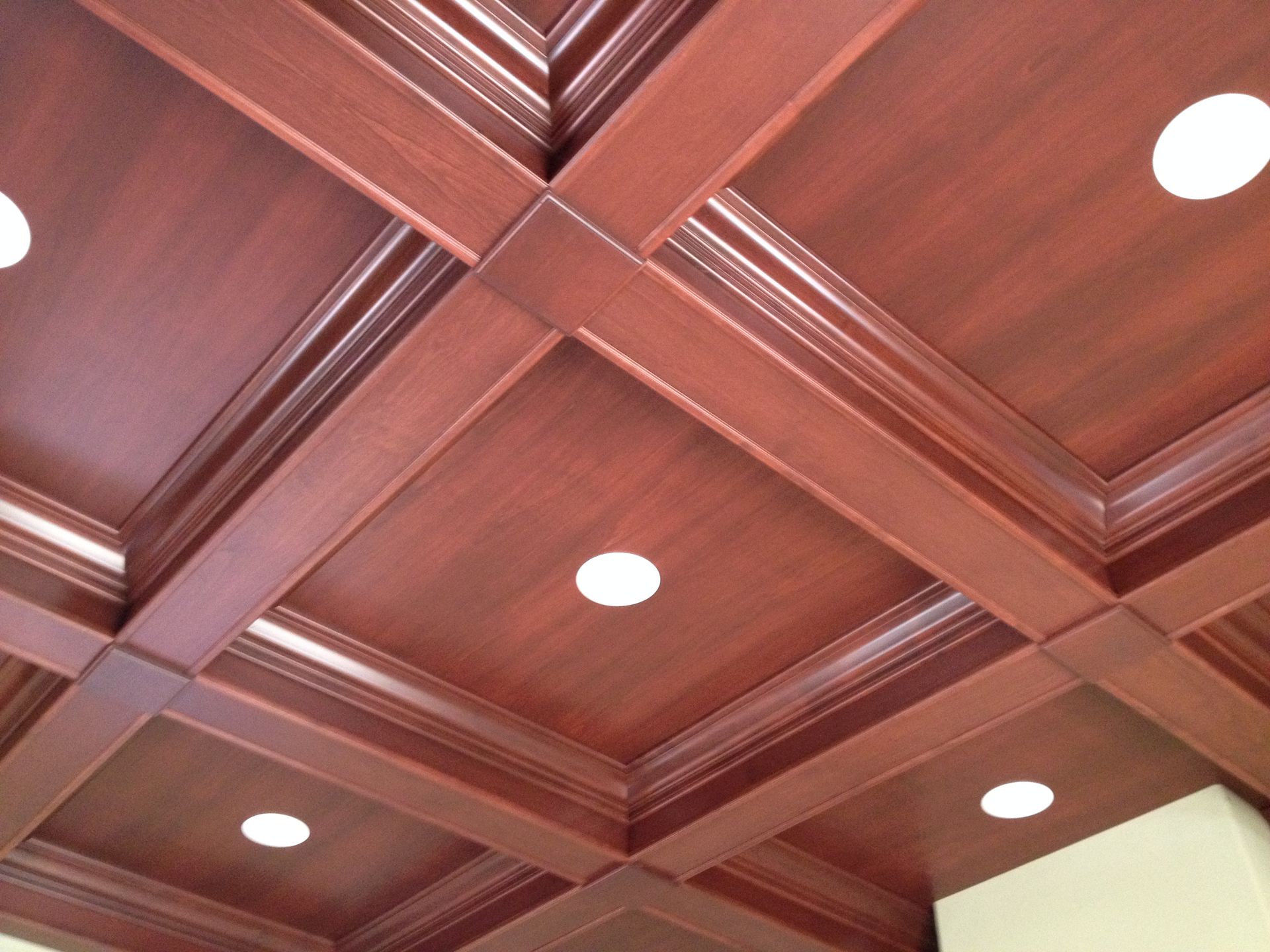 Wooden coffered ceiling with recessed white lights.