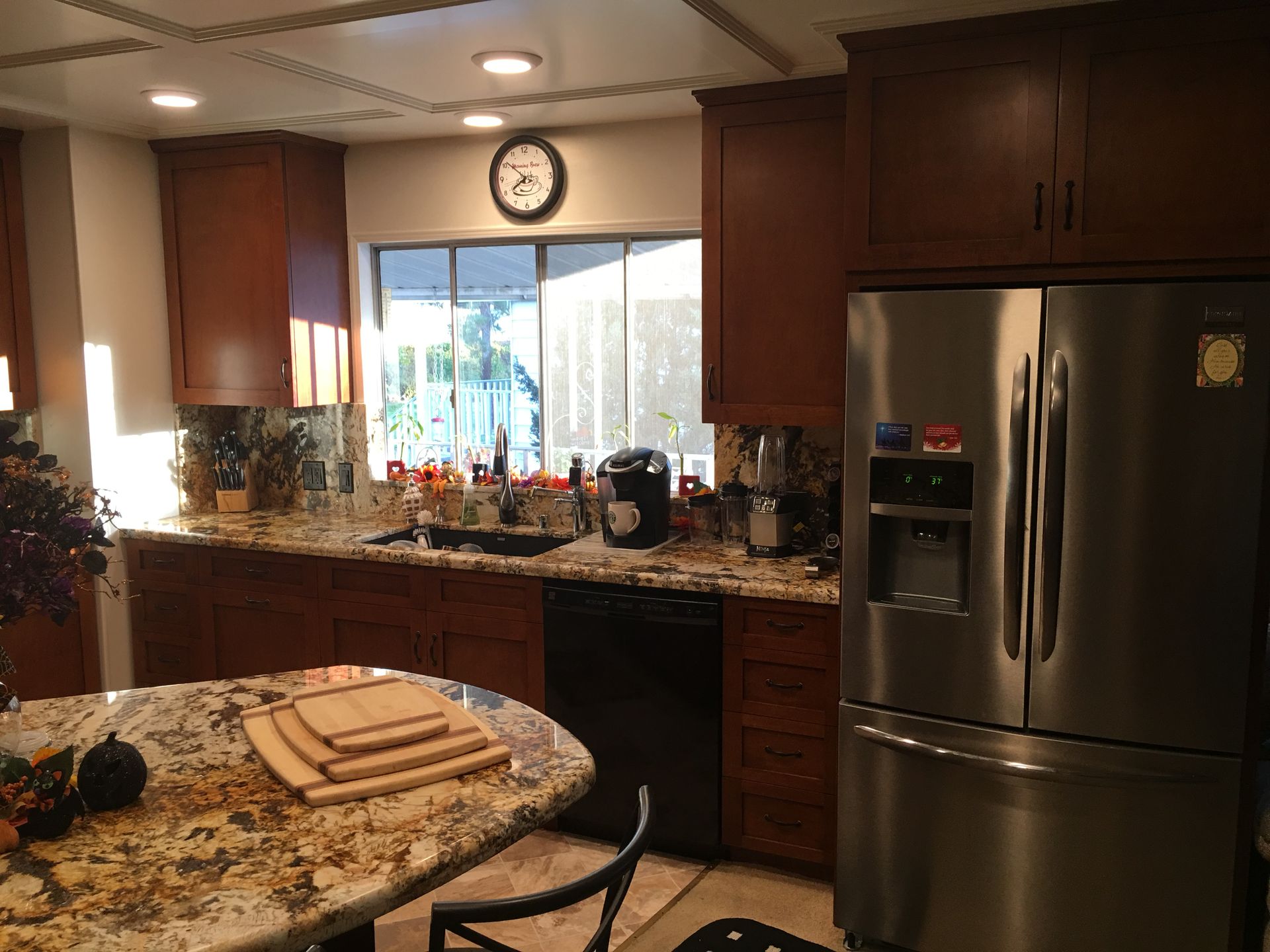 Kitchen with wood cabinets, granite countertops, and stainless steel refrigerator.
