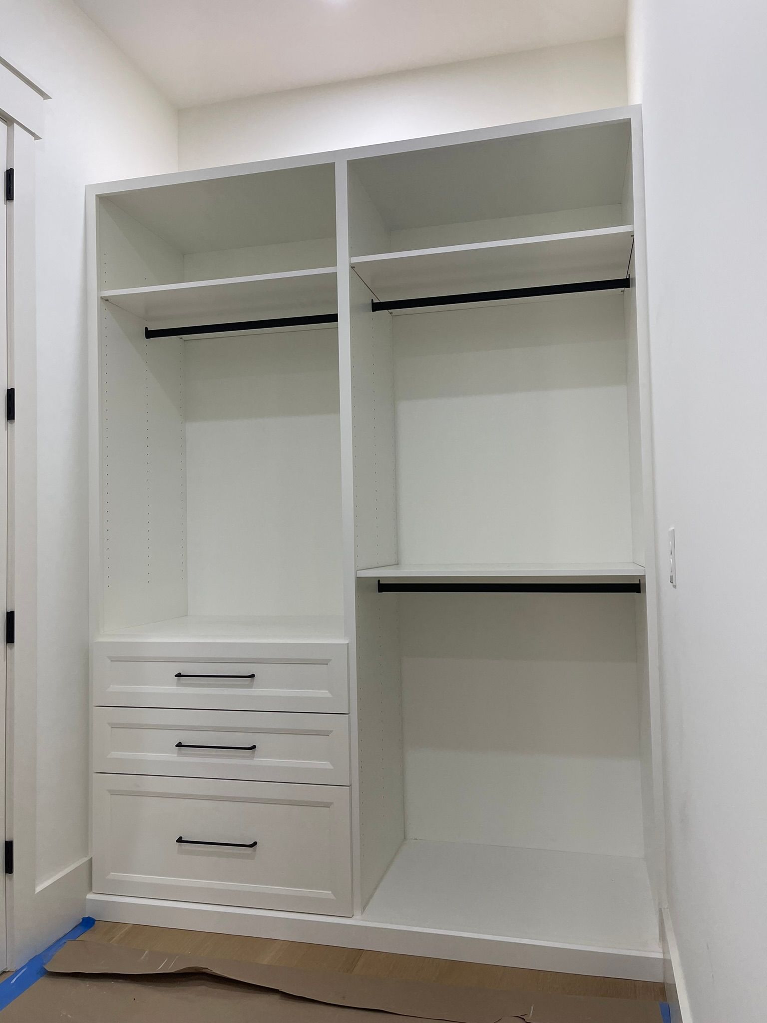 White closet with drawers, shelves, and hanging rods.