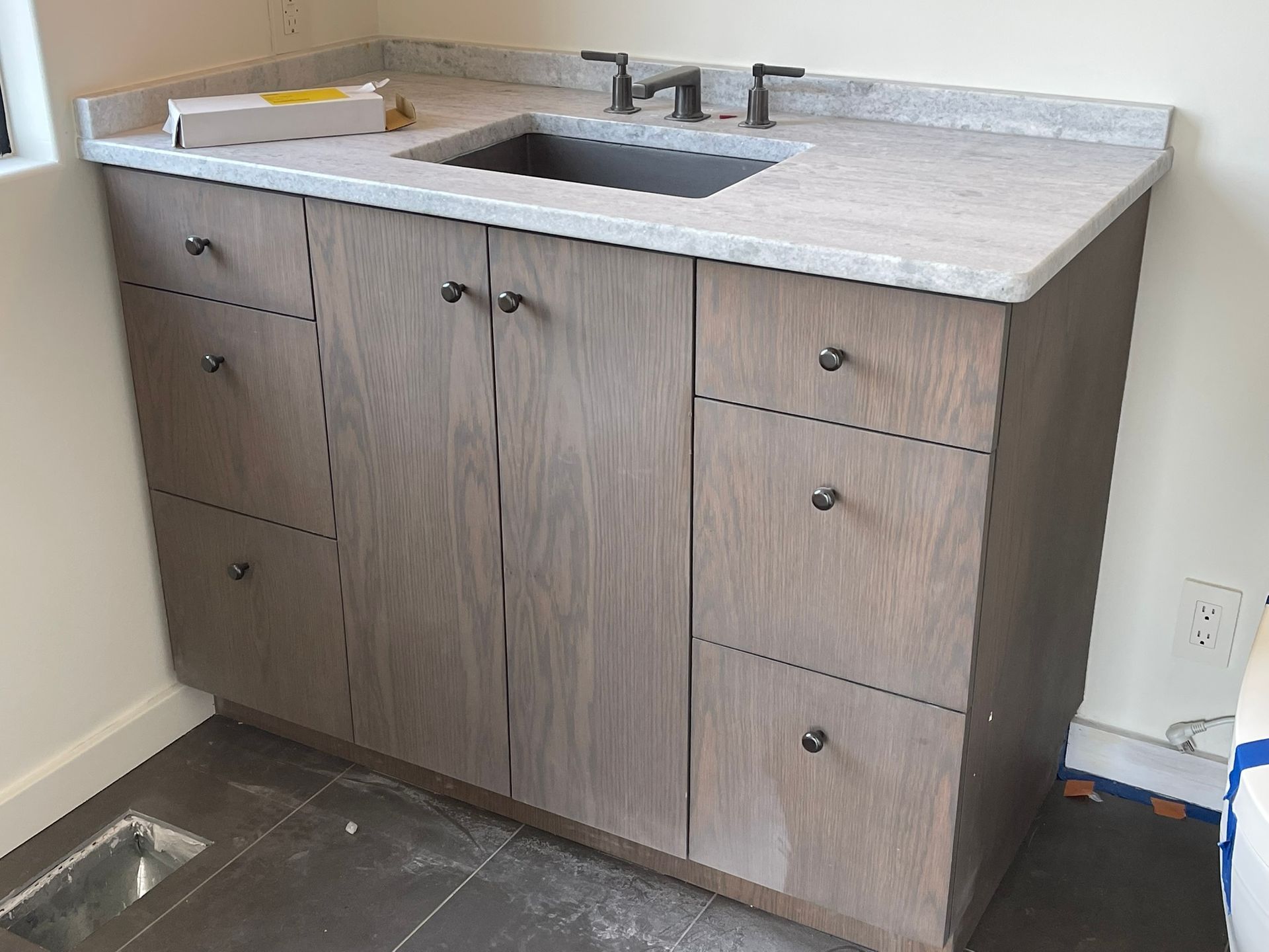 Bathroom vanity with gray cabinets, countertop, and sink.