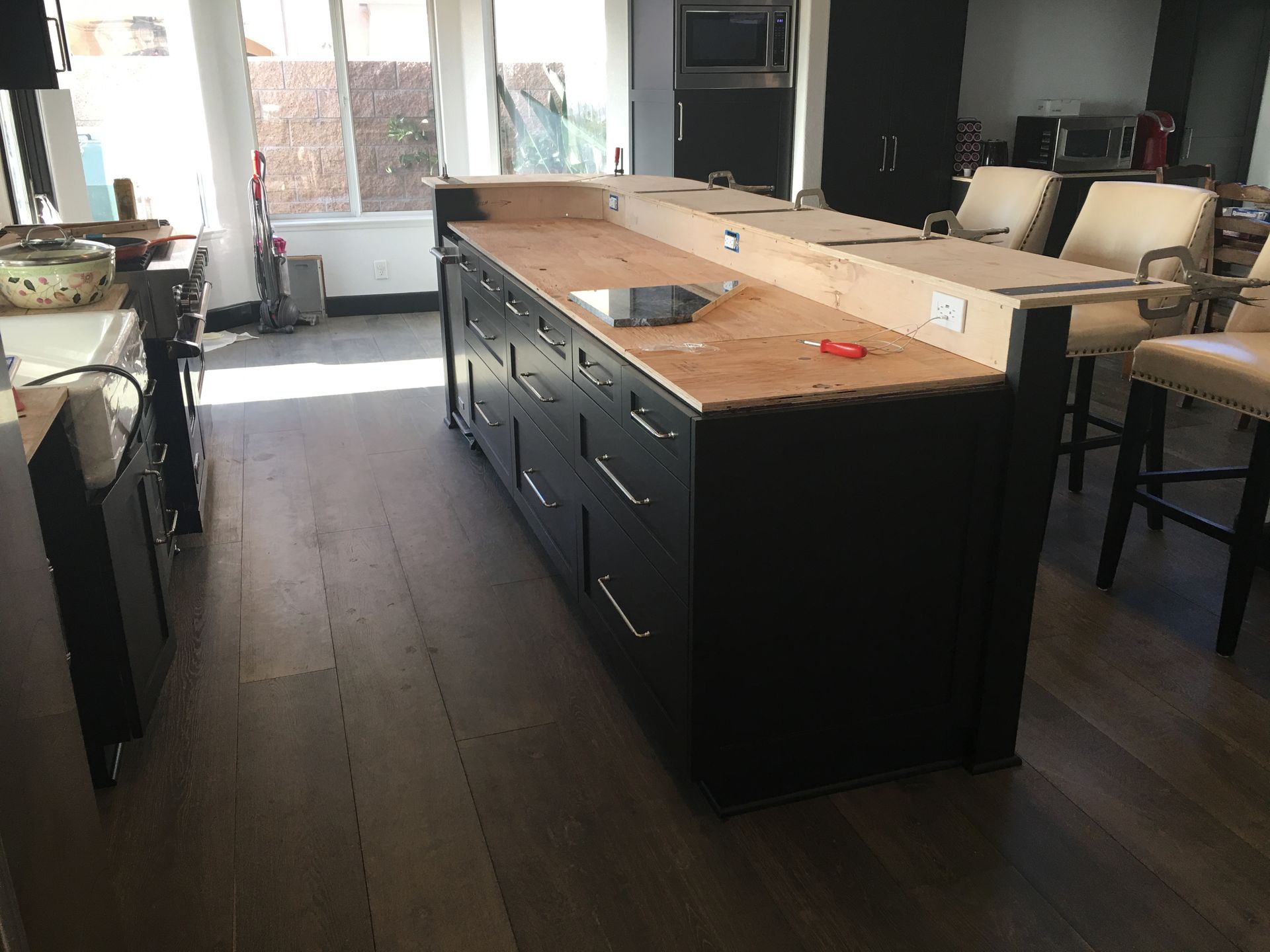 Kitchen island with black cabinets and wood countertop, partially built.