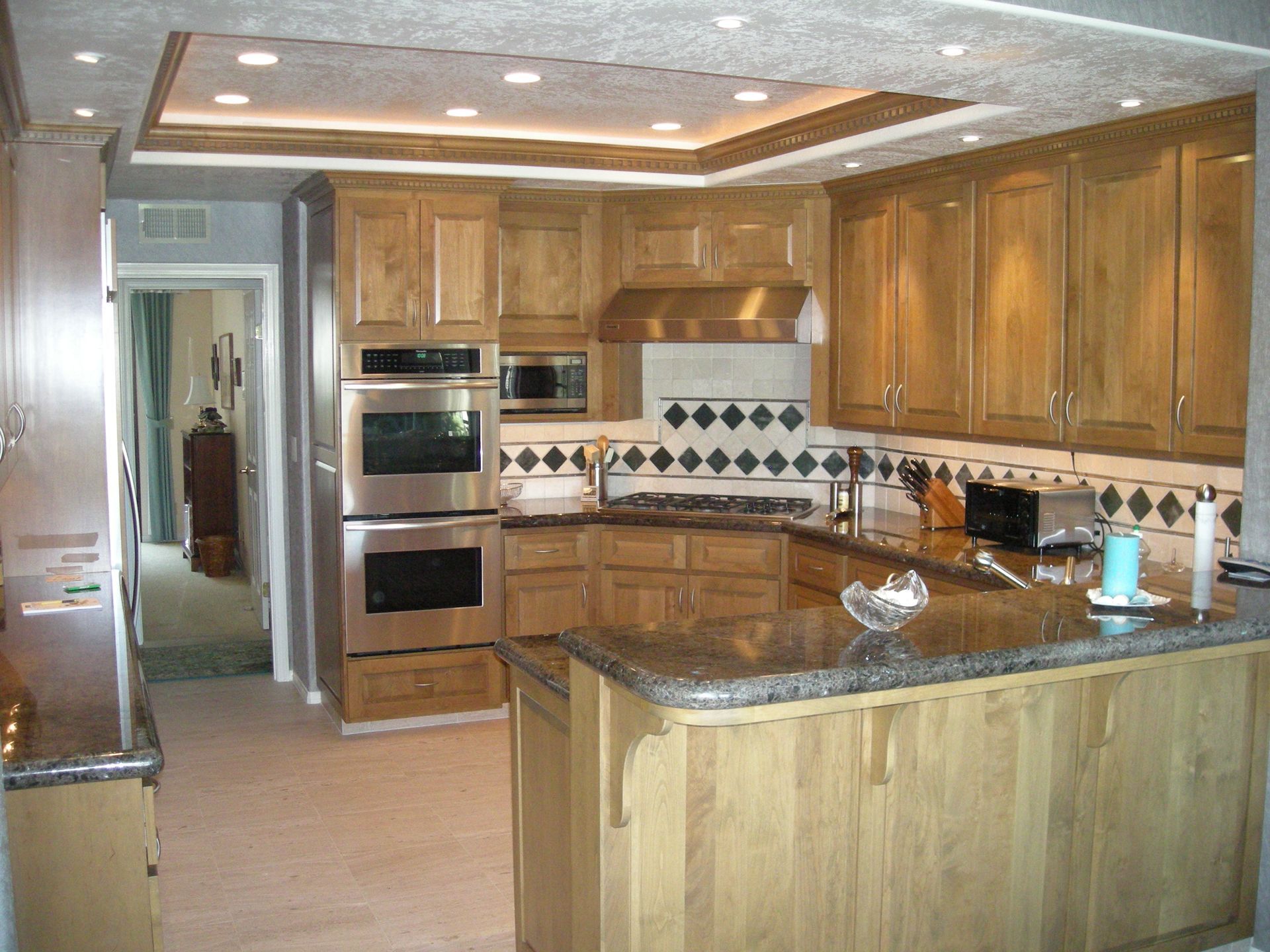 Kitchen with wood cabinets, stainless steel appliances, and granite countertops.