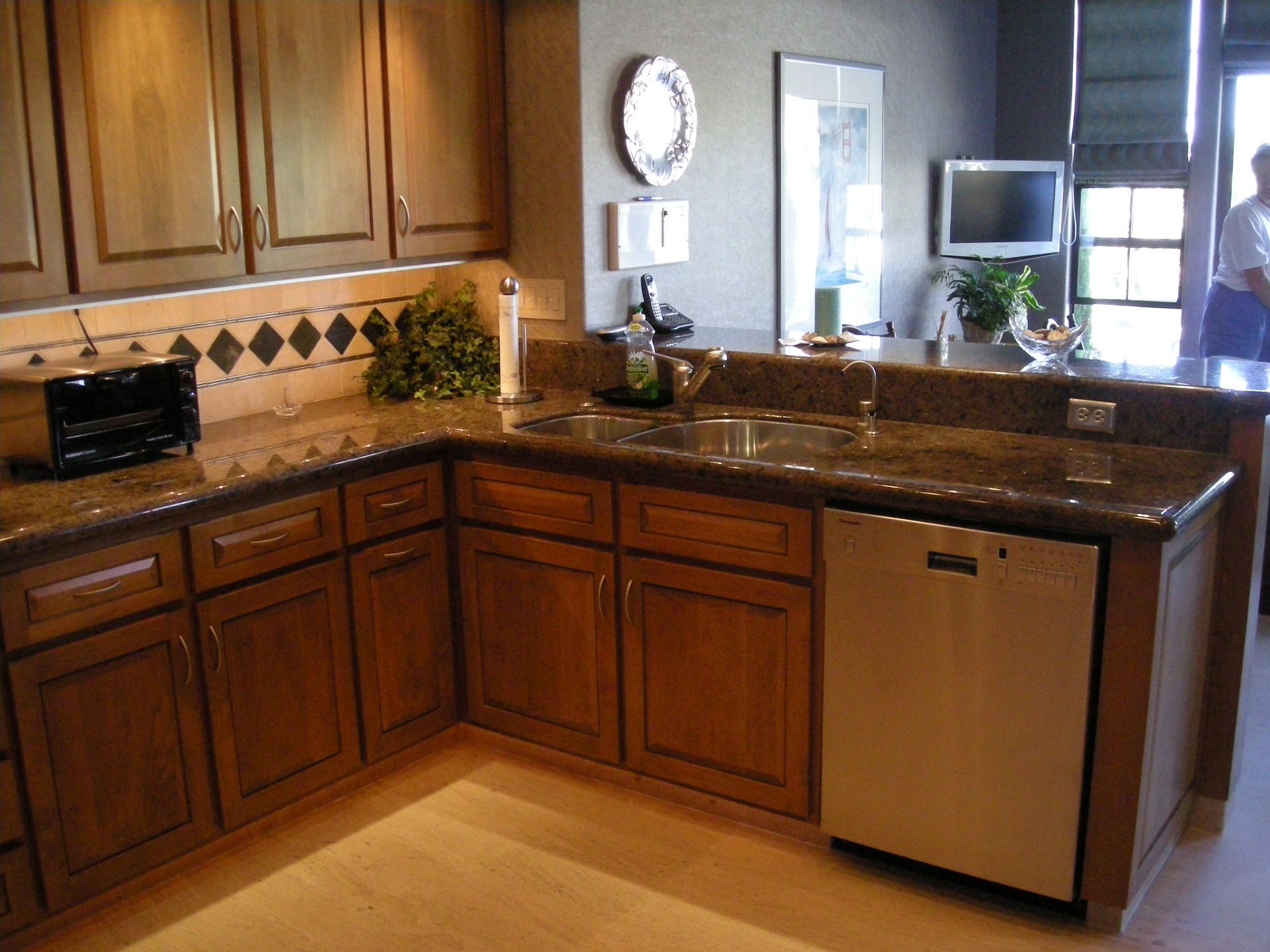 Kitchen with wooden cabinets, granite countertops, and stainless steel dishwasher.