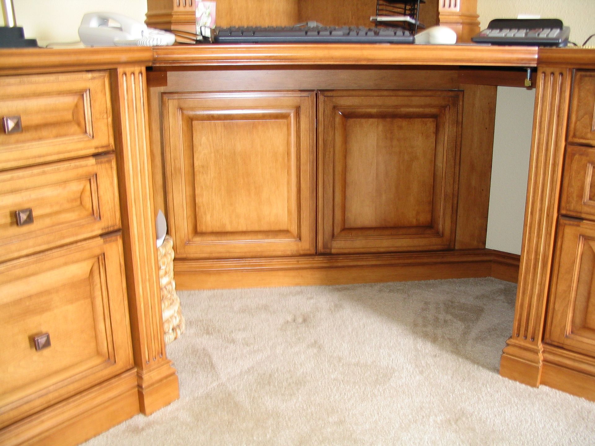 Wooden desk with drawers, cabinets, and a keyboard.
