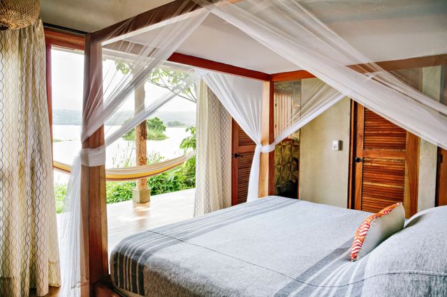 A bedroom with a four poster bed and a mosquito net.
