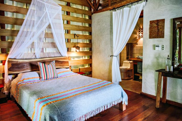A bedroom with a mosquito net over the bed.